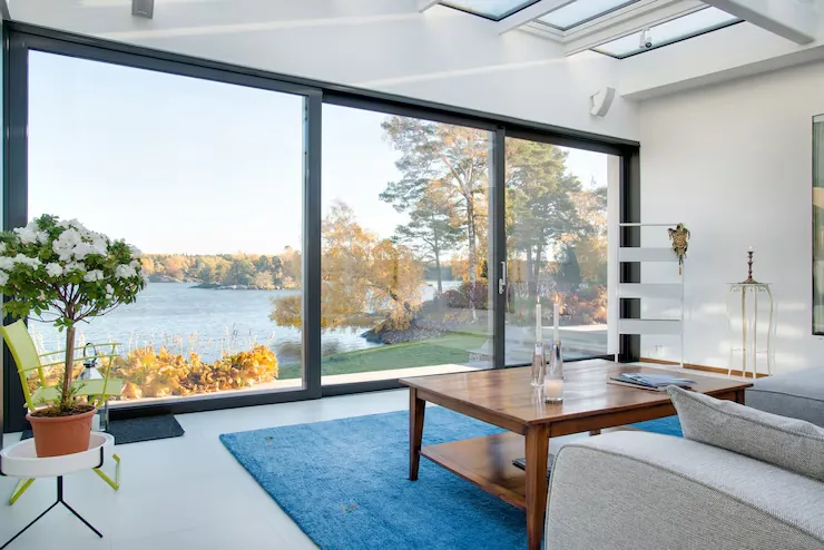 Living con grandes ventanas de aluminio y vista al exterior